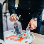 man taking glass bottle from tray