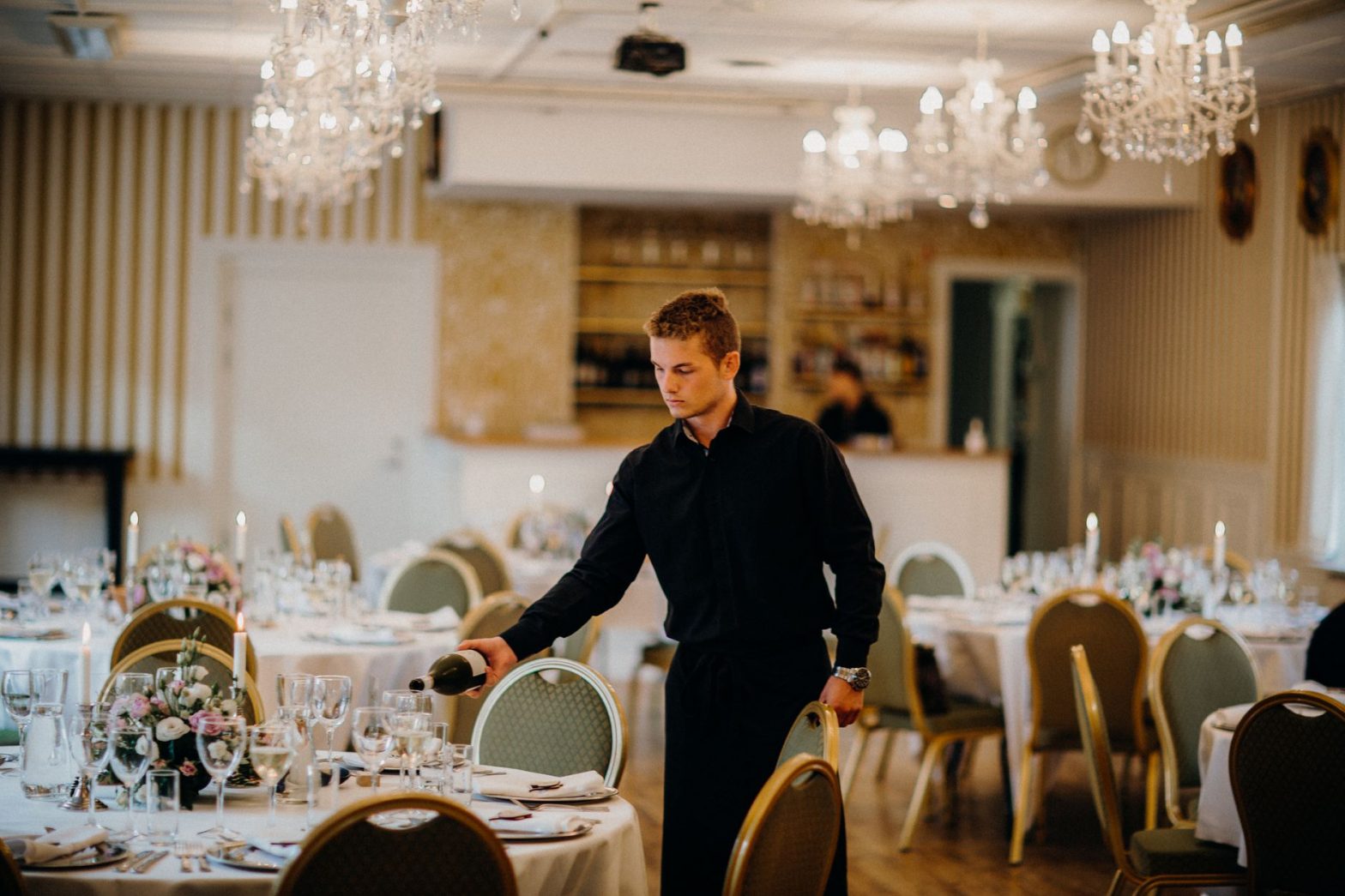 man in black long sleeve shirt pouring wine