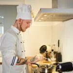 man in white chef uniform holding stainless spoon