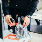 view on man putting cola bottles on tray