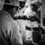 black and white photography of people working in a kitchen