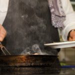 man preparing food on pan