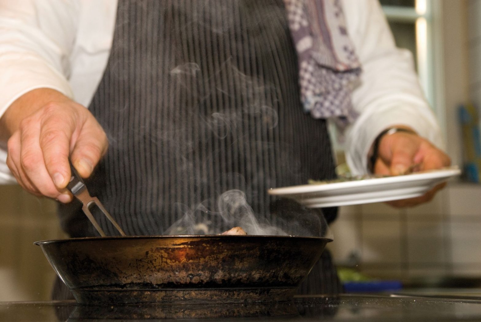 man preparing food on pan