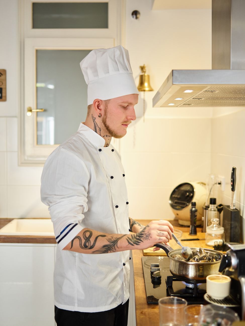 man in white chef uniform holding stainless spoon